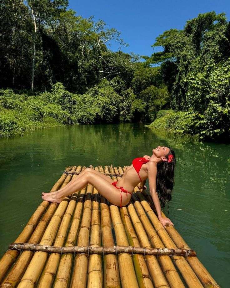 Woman in red bikini on bamboo river raft