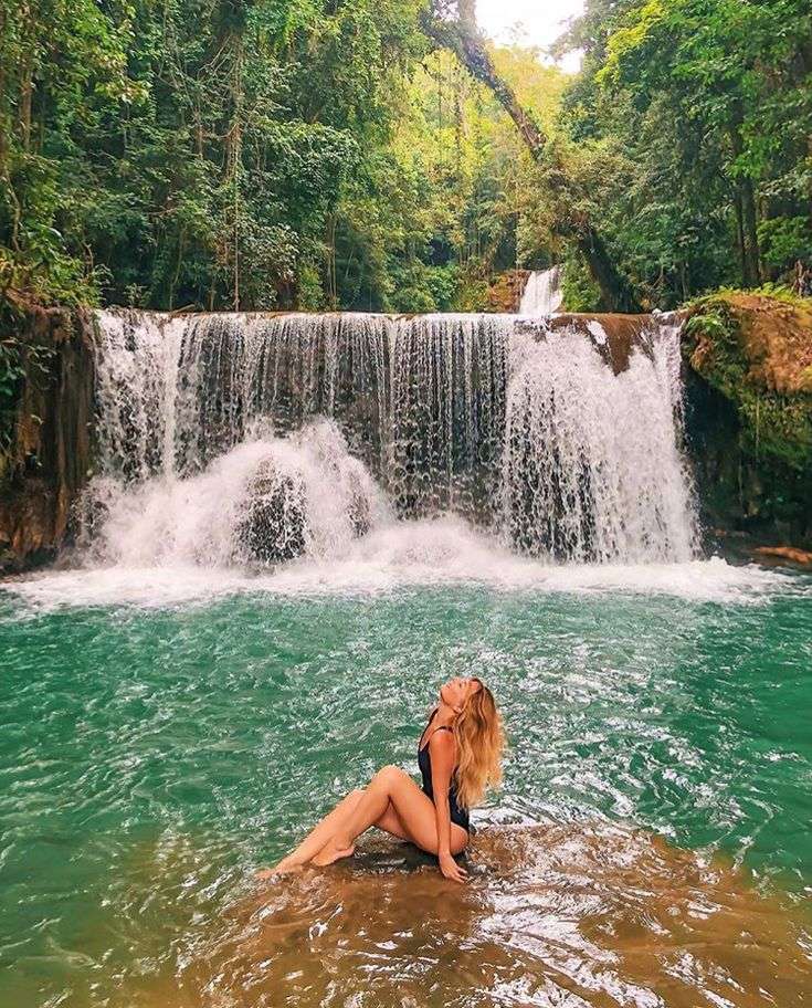 Woman sitting under tropical Jamaican YS Falls